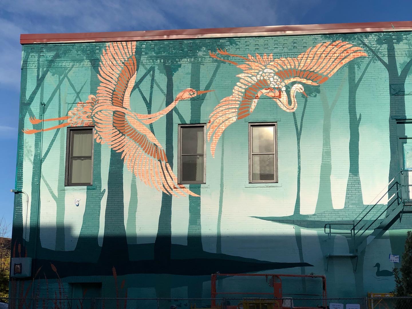 Full daytime view of the Sanctuary mural wrapping the downtown building.