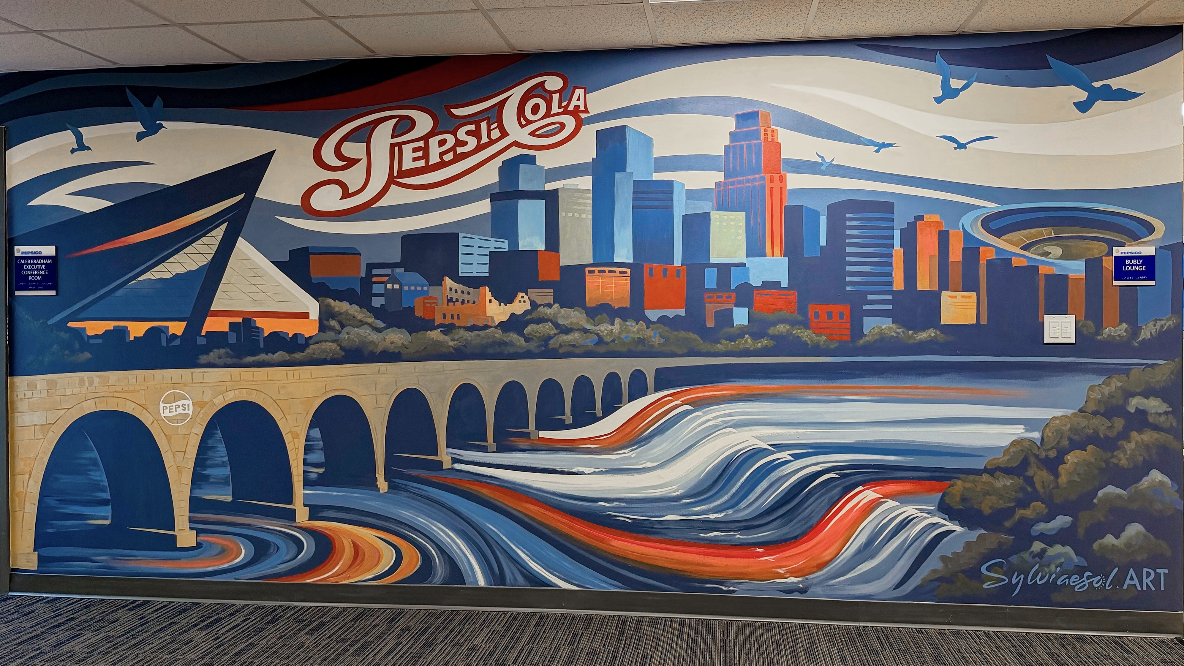 Mural of the Minneapolis skyline and Stone Arch Bridge with retro Pepsi-Cola lettering.