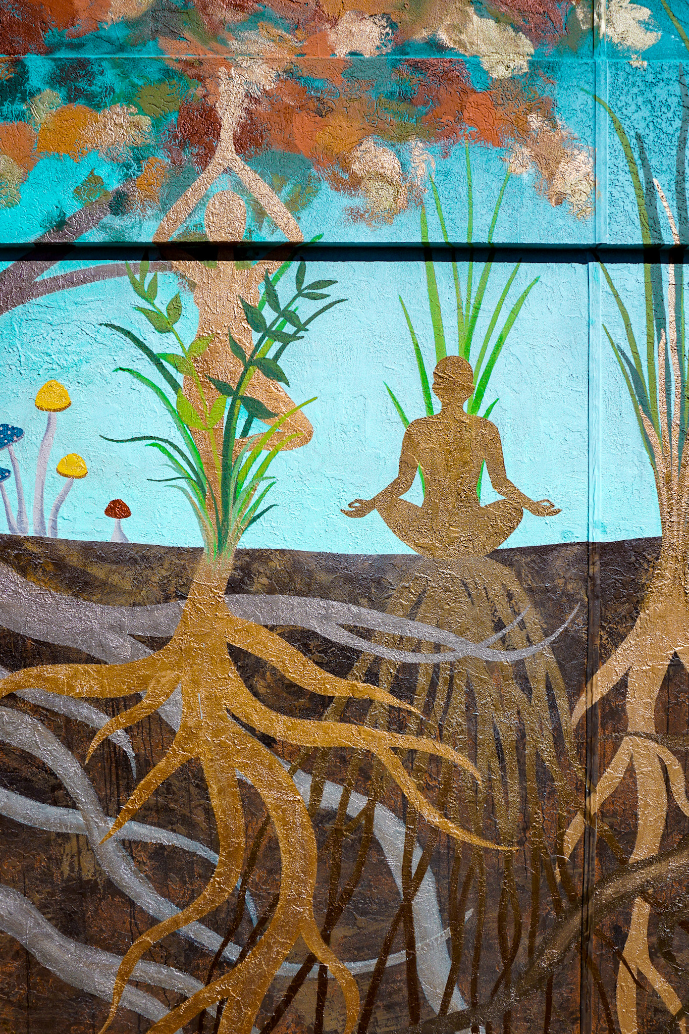 Detail of gold-leaf roots beneath a meditating figure and a teal sky.
